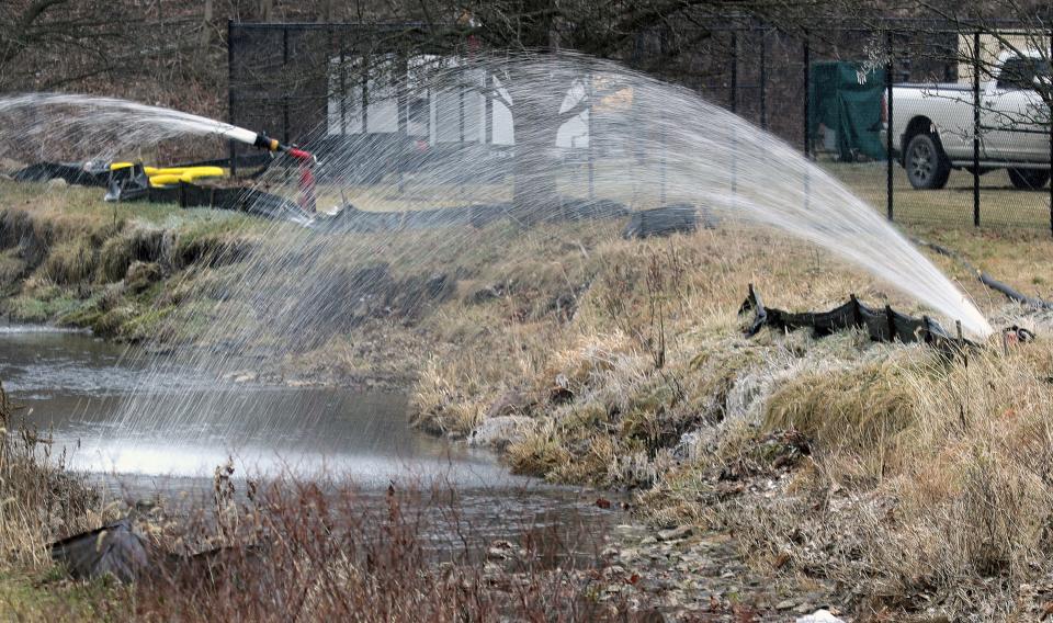 Creek water is sprayed back into Leslie Run creek on Friday in East Palestine, Ohio.