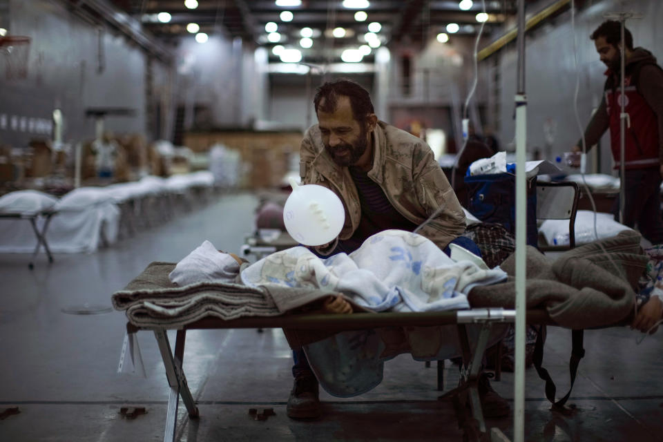 A man plays with his child in a makeshift hospital set up at Turkish Bayraktar warship anchored in a port near Iskenderun city, southern Turkey, Tuesday, Feb. 14, 2023. Thousands left homeless by a massive earthquake that struck Turkey and Syria a week ago packed into crowded tents or lined up in the streets for hot meals as the desperate search for survivors entered what was likely its last hours. (AP Photo/Francisco Seco)