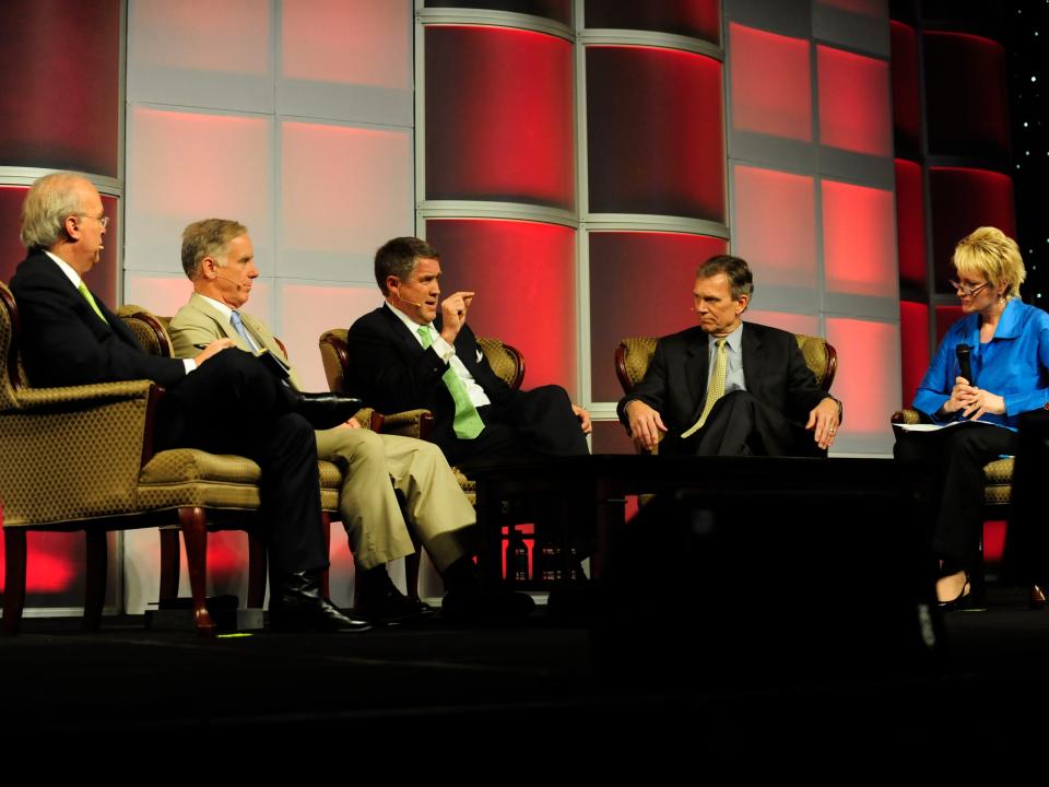 Former senator William Frist speaks at a healthcare panel with two people sitting on either side of him