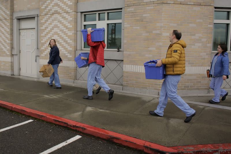 Harborview Medical Center’s home assessment team carry protective and testing supplies while preparing to visit the home of a person potentially exposed to novel coronavirus