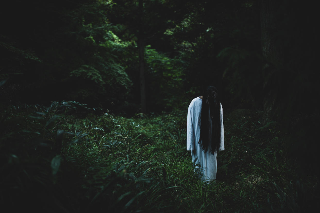 A long haired woman disguised as a ghost in a forest, illustrating a story on Pontianak.