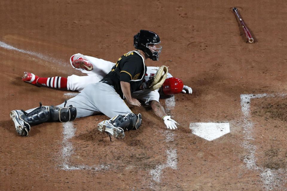 St. Louis Cardinals' Kolten Wong is tagged out at home by Pittsburgh Pirates catcher Jacob Stallings, front, to end the fifth inning of a baseball game Friday, July 24, 2020, in St. Louis. (AP Photo/Jeff Roberson)