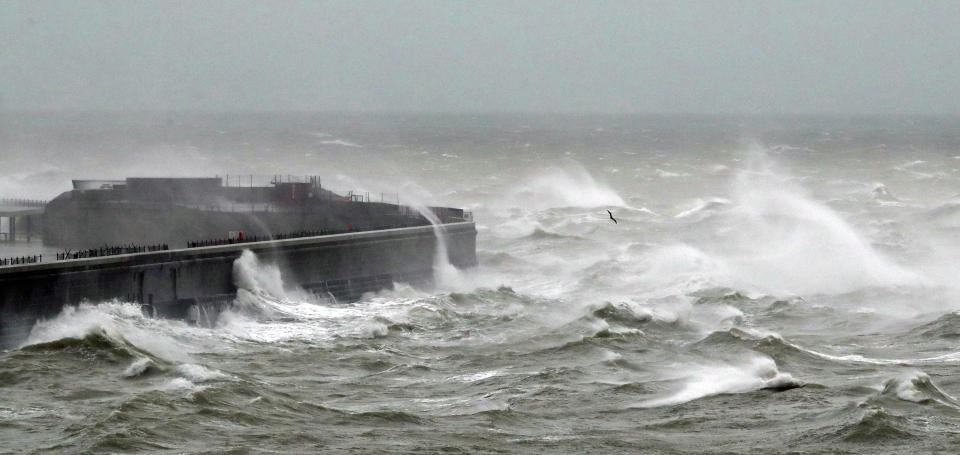 Waves crash over the harbour wall in Dover, Kent, during strong winds and rain, whilst a lone seagull braves the weather.