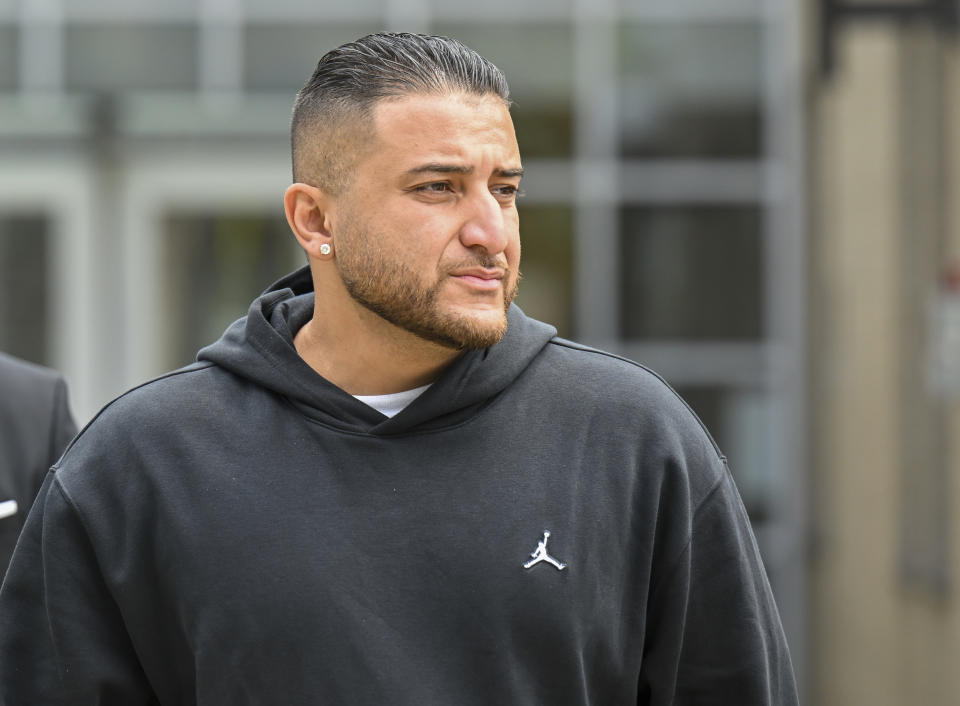 Haris Hussain, brother of Nauman Hussain who ran the limousine company involved in the 2018 crash that killed 20 people, walks outside during a lunch break in a new trial in Schoharie, N.Y., on Monday, May 1, 2023. Judge Peter Lynch rejected a plea agreement for Nauman Hussain to avoid prison time. (AP Photo/Hans Pennink)