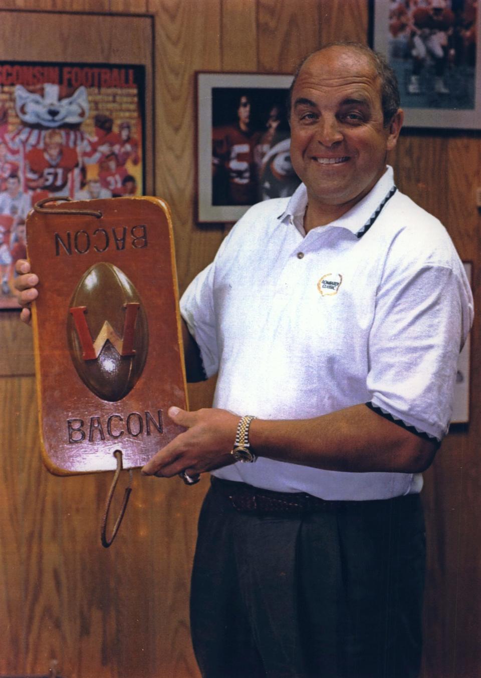 Badgers football coach Barry Alvarez holds the Slab of Bacon Trophy in 1994. The traveling trophy went to the winner of the annual Wisconsin-Minnesota game. According to uwbadgers.com, the trophy was lost in the mid 1940s and was replaced by Paul Bunyan's Axe in 1948.