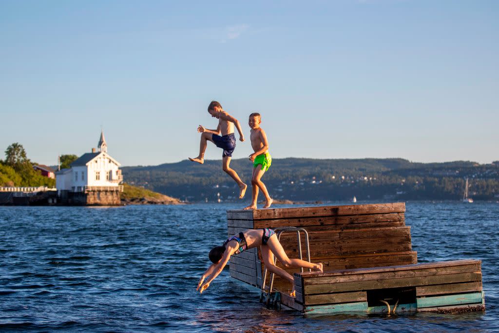 Norwegian children enjoying the fjords during the summer - getty