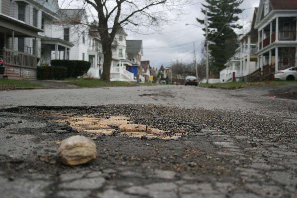 A view of damage to the surface of Shaw Street, east of Sunset Avenue in Utica.