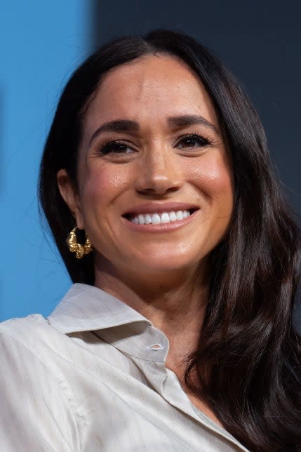 Smiling woman in a white blouse at a speaking event