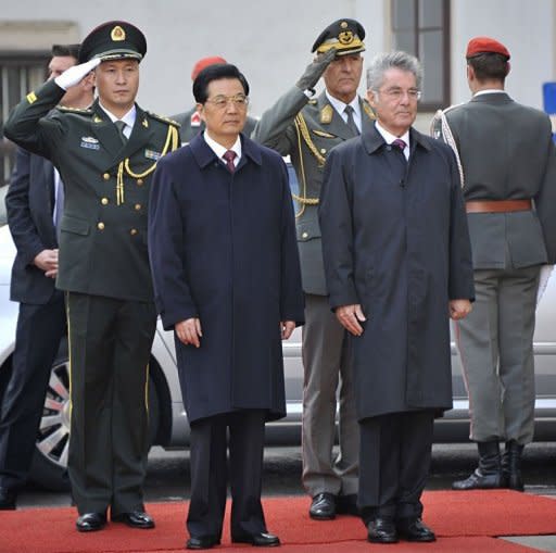Austrian President Heinz Fischer (R) and his Chinese counterpart Hu Jintao listen to national anthems during a welcoming ceremony in the courtyard of Hofburg palace. China pledged "active support" to debt-stricken Europe and said it was "convinced" the EU could work through its current debt crisis, as Hu visited Vienna on Monday ahead of a G20 meeting