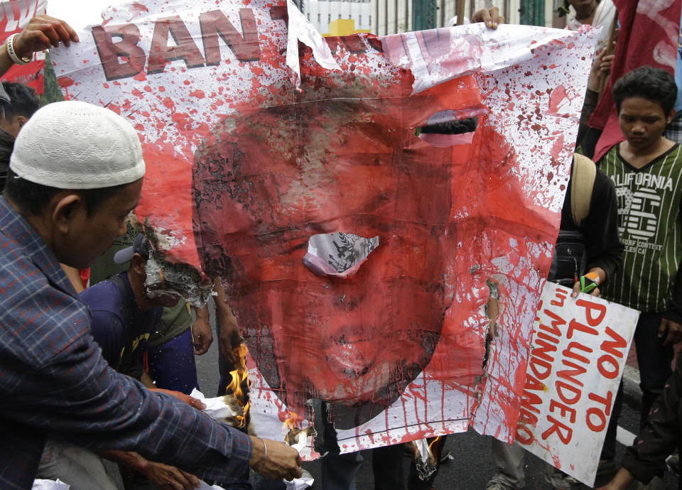 <p>Protesters burn a picture of President Donald Trump during a rally near the U.S. Embassy to protest this weekend’s visit of Trump on Saturday, Nov. 11, 2017 in Manila, Philippines. (Photo: Aaron Favila/AP) </p>