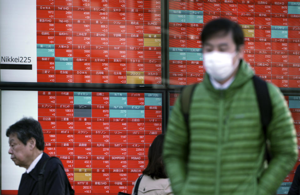 People walk past an electronic stock board showing Japan's Nikkei 225 index at a securities firm in Tokyo Monday, Feb. 4, 2019. Asian markets were mixed Monday as traders questioned an imminent meeting between American and Chinese officials to work on disagreements ranging from technology development to trade. (AP Photo/Eugene Hoshiko)