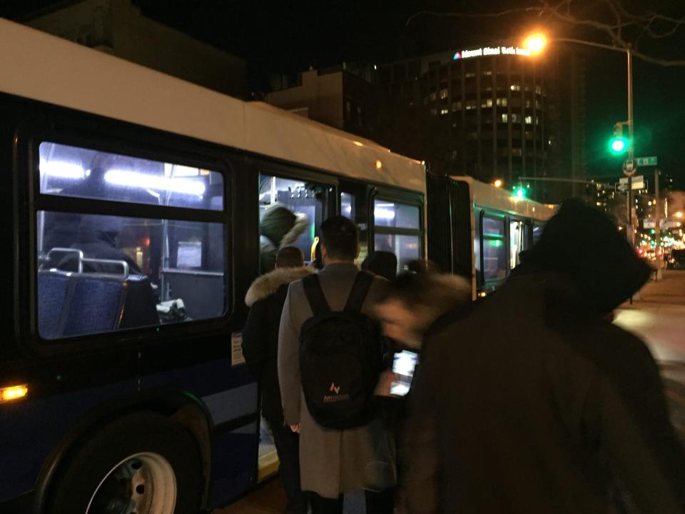 People in NYC boarding a bus.