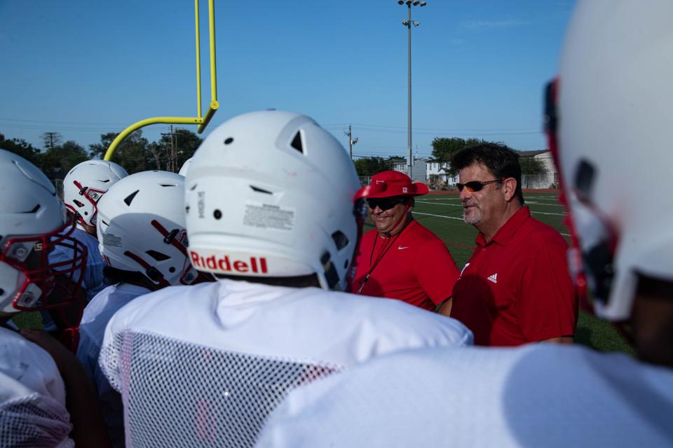 Ray's football team huddles around head coach Craig Charlton, right, during practice on Thursday, Aug. 4, 2022 at the high school.
