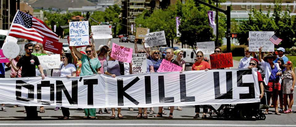 FILE - In this June 27, 2017, file photo, protesters block a street during a protest against the Republican bill in the U.S. Senate to replace President Barack Obama's health care law, in Salt Lake City. The Trump administration will allow Medicaid expansion with a work requirement in Utah, a decision that came Monday, Dec. 23, 2019, despite courts taking a dim view of the requirement in other states. (AP Photo/Rick Bowmer, File)