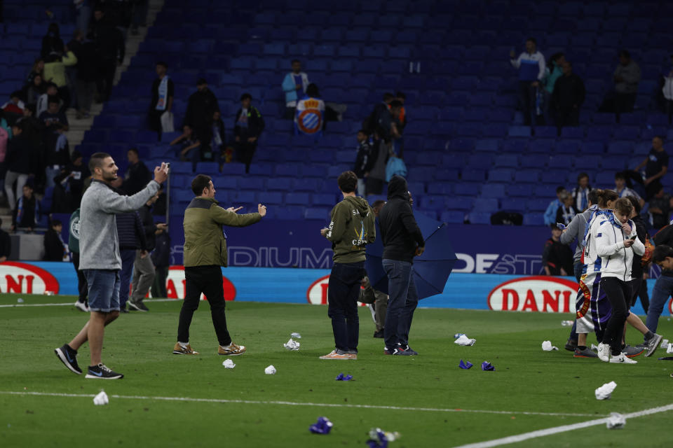 Supporters run in the file after the Spanish La Liga soccer match between Espanyol and Barcelona at the RCDE stadium in Barcelona, Sunday, May 14, 2023. (AP Photo/Joan Monfort)