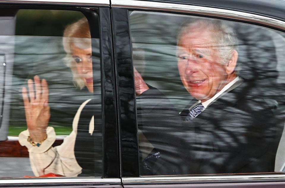 Britain's King Charles III and Britain's Queen Camilla wave as they leave by car from Clarence House in London on Tuesday (AFP via Getty Images)