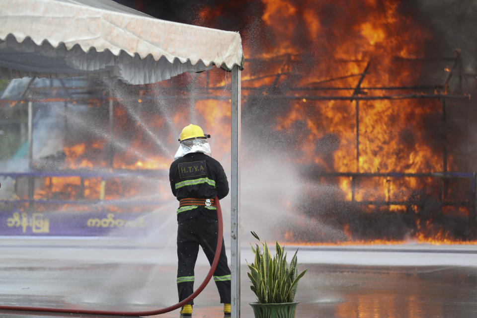 A firefighter sprays water as flames and smoke rise from burning illegal drugs during a destruction ceremony to mark International Day against Drug Abuse and Illicit Trafficking outside Yangon, Myanmar, Friday, June 26, 2020. More than $839 million of seized illegal drugs were destroyed in the country on Friday, officials said. Myanmar has long been a major source of illegal drugs for East and Southeast Asia, despite repeated efforts to crack down. (AP Photo/Thein Zaw)