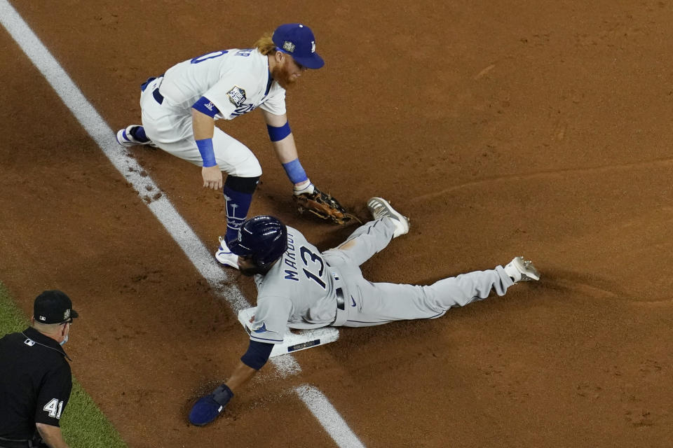 Tampa Bay Rays' Manuel Margot is safe at third past Los Angeles Dodgers third baseman Justin Turner on a ball hit by Joey Wendle during the second inning in Game 2 of the baseball World Series Wednesday, Oct. 21, 2020, in Arlington, Texas. (AP Photo/David J. Phillip)