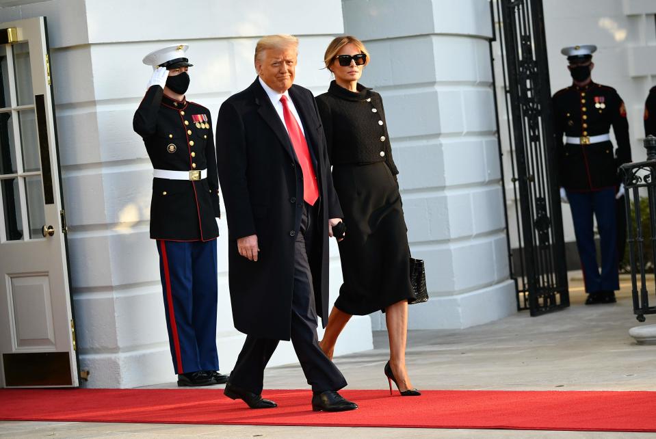 President Donald Trump and first lady Melania make their way to board Marine One before departing from the South Lawn of the White House in Washington on Jan. 20, 2021.