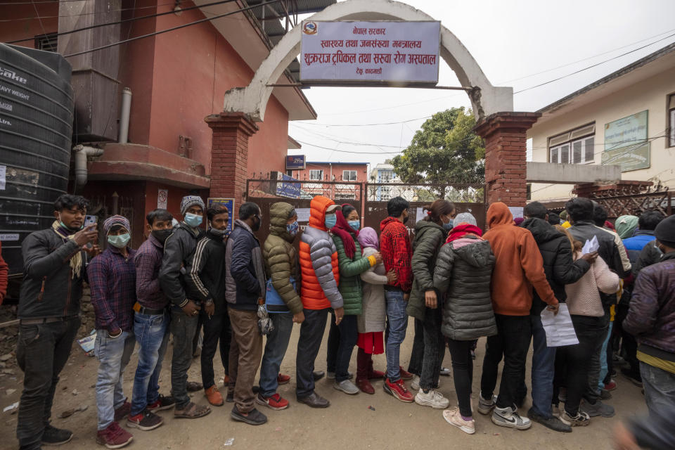 Nepalese people queue up to get vaccinated after government made vaccination cards mandatory for people to access public services in Kathmandu, Nepal, Thursday, Jan. 20, 2022. (AP Photo/Niranjan Shrestha)
