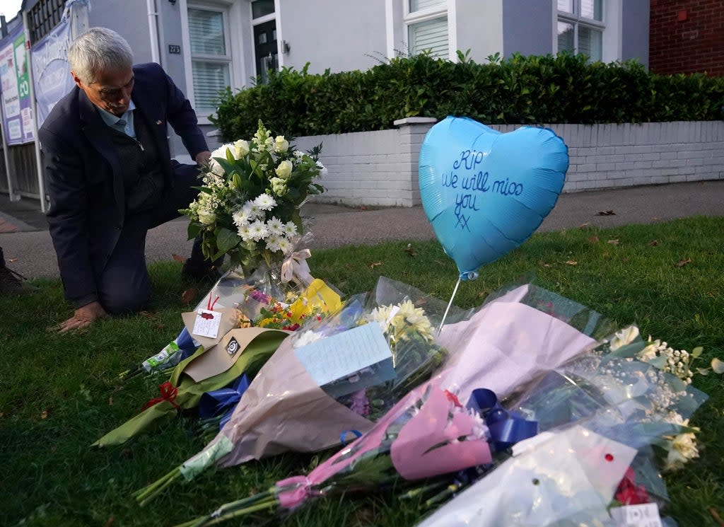 A man lays flowers in memory of Sir David Amess in Leigh-on-Sea  (PA)