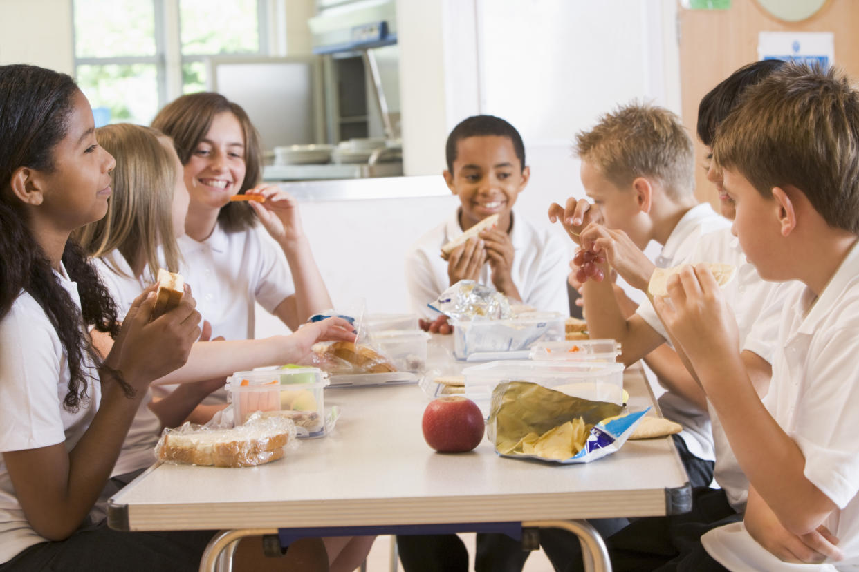 Schoolchildren enjoying their packed lunches in a school cafeteria