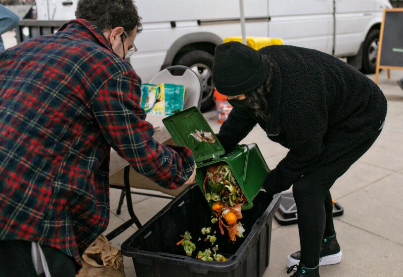 LOS ANGELES, CA - JANUARY 18: Andrew Davidov's food waste is being weighed by Kevelin Barcenas-Garcia Angeleno a volunteer with LA Compost at their booth at Highland Park Farmers Market on Tuesday, Jan. 18, 2022 in Los Angeles, CA. (Jason Armond / Los Angeles Times)