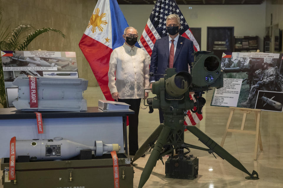U.S. National Security Advisor Robert Robert O'Brien, right, and Philippines' Secretary of Foreign Affairs Teodoro Locsin Jr. pose in between precision-guided ammunitions and other defense articles during a turnover ceremony at the Department of Foreign Affairs in Pasay City, Philippines Monday, Nov. 23, 2020. (Eloisa Lopez/Pool Photo via AP)