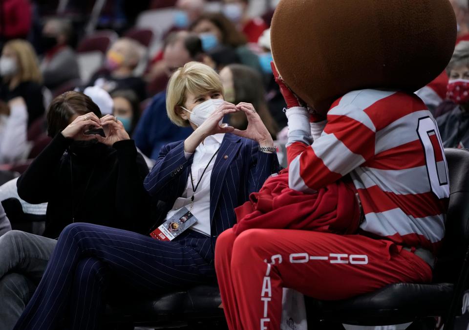 Dr. Kristina Johnson, Ohio State's president, gives a heart gesture to Brutus Buckeye during the third quarter of the NCAA women's basketball game between the Ohio State Buckeyes and the Michigan State Spartans at Value City Arena in Columbus on Jan. 12, 2022. 