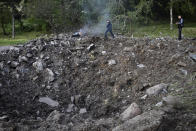 Police officers inspect a crater after a Russian missile attack in Zaporizhzhia, Ukraine, Wednesday, May 8, 2024. (AP Photo/Andriy Andriyenko)