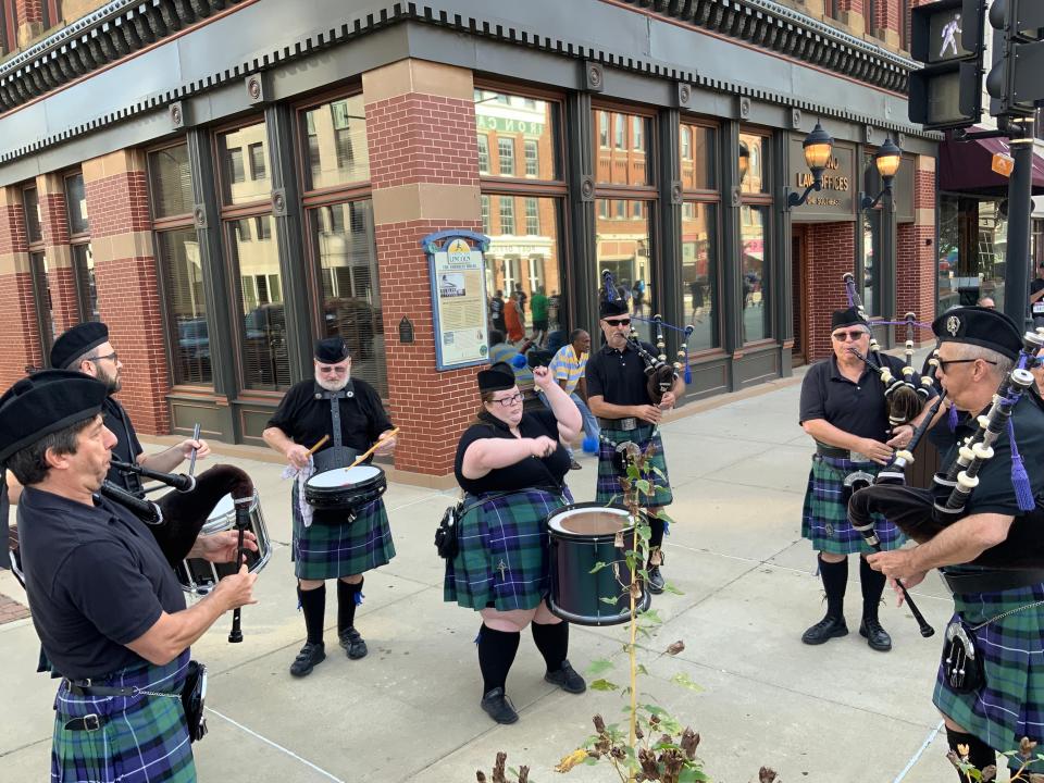 Members of The St. Andrew’s Society of Central Illinois play their bagpipes and drums to mark the start of the Fat Ass 5K & Street Party in downtown Springfield.