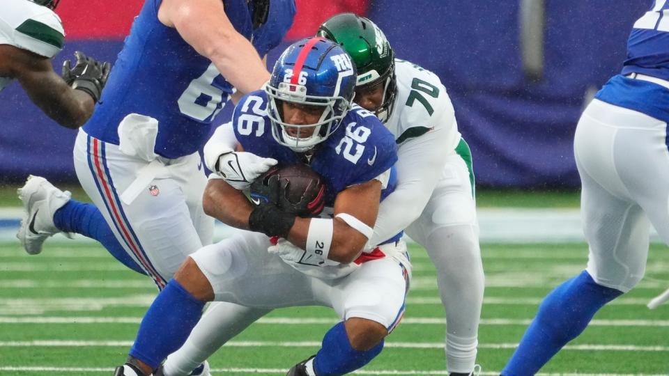 Oct 29, 2023; East Rutherford, New Jersey, USA; New York Jets defensive tackle Quinton Jefferson (70) stops New York Giants running back Saquon Barkley (26) in the first half at MetLife Stadium.