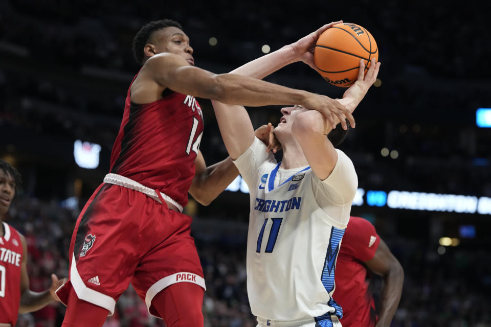 North Carolina State guard Casey Morsell, left, fouls Creighton center Ryan Kalkbrenner during the second half of a first-round college basketball game in the men's NCAA Tournament on Friday, March 17, 2023, in Denver. (AP Photo/David Zalubowski)