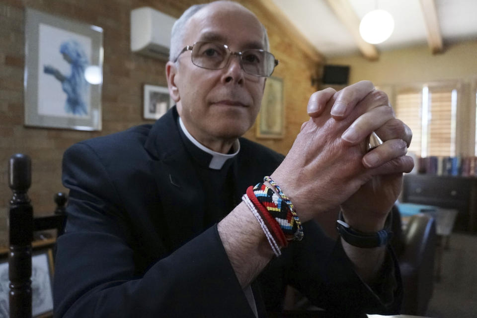 Bishop Mark Seitz of El Paso poses in his office in El Paso, Texas, on Monday, April 4, 2022. The friendship bracelets on his wrist were braided by girls housed at a shelter on nearby Fort Bliss Army base for unaccompanied minors who crossed the U.S.-Mexican border. The Catholic bishop has often celebrated Mass there and found striking witness of faith among the teens. (AP Photo/Giovanna Dell'Orto)
