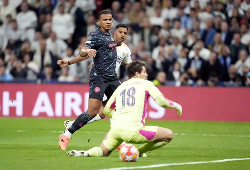 Real Madrid's Rodrygo (C) scores his side's second goal during the UEFA Champions League quarter-final first leg soccer match between Real Madrid and Manchester City at the Santiago Bernabeu Stadium. Nick Potts/PA Wire/dpa