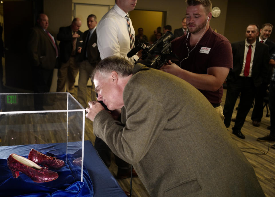 FILE - Rhys Thomas, author of "the Ruby Slippers of Oz" takes a photo of a pair of ruby slippers once worn by Judy Garland in the "The Wizard of Oz", Sept. 4, 2018, in Brooklyn Center, Minn. The man who has admitted stealing the slippers, gave into the temptation of “one last score” after an old mob associate led him to believe the shoes must be adorned with real jewels to justify their $1 million insured value according to a new memo filed ahead of his Monday, Jan. 29, 2024, sentencing in Duluth, Minn. (Richard Tsong-Taatarii/Star Tribune via AP, FILE)