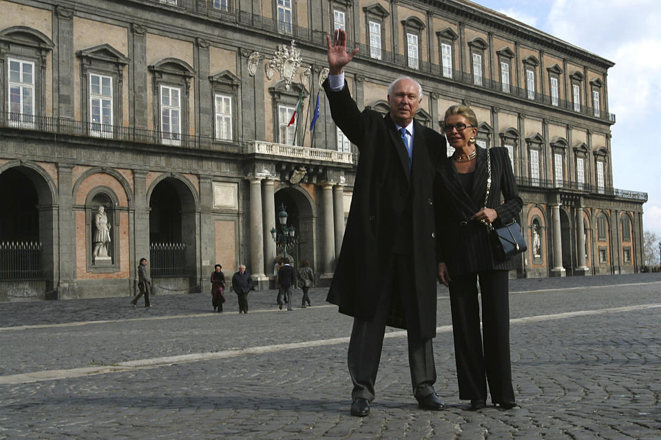 Prince Vittorio Emanuele of Savoy, left, waves flanked by and his wife Marina Doria outside the Palazzo Reale royal palace in Naples' Piazza del Plebiscito, southern Italy, May 15, 2003. Prince Vittorio Emanuele, son of Italy’s last king, Umberto II, has died. He was 86. The Savoy Royal House said in a statement that he died on Saturday, Feb. 3, 2024, in Geneva, Switzerland. Vittorio Emanuele was obliged to leave Italy for exile when he was only 9, after Italians voted to abolish the monarchy in 1946. (Roberto Monaldo/LaPresse via AP)