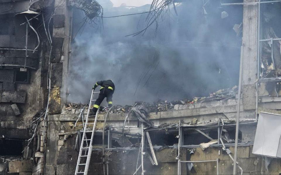 A fireman scales a ladder to assess the damage in the central Ukrainian city