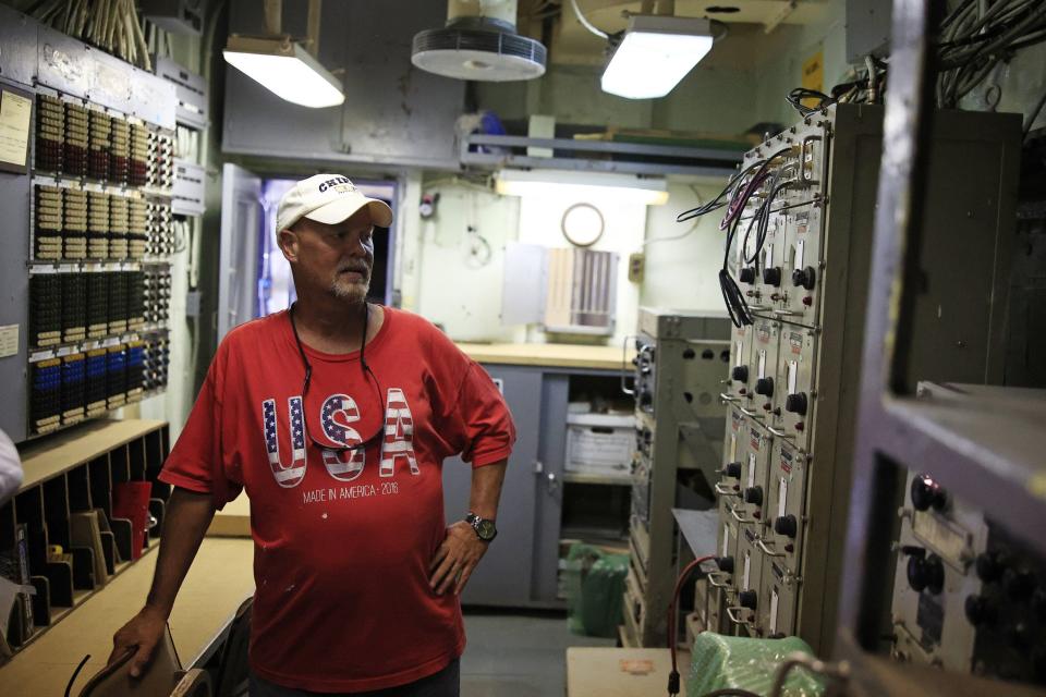 USS Orleck ship manager Craig Bernat looks over the period gear in the ship's communications room on June 10.