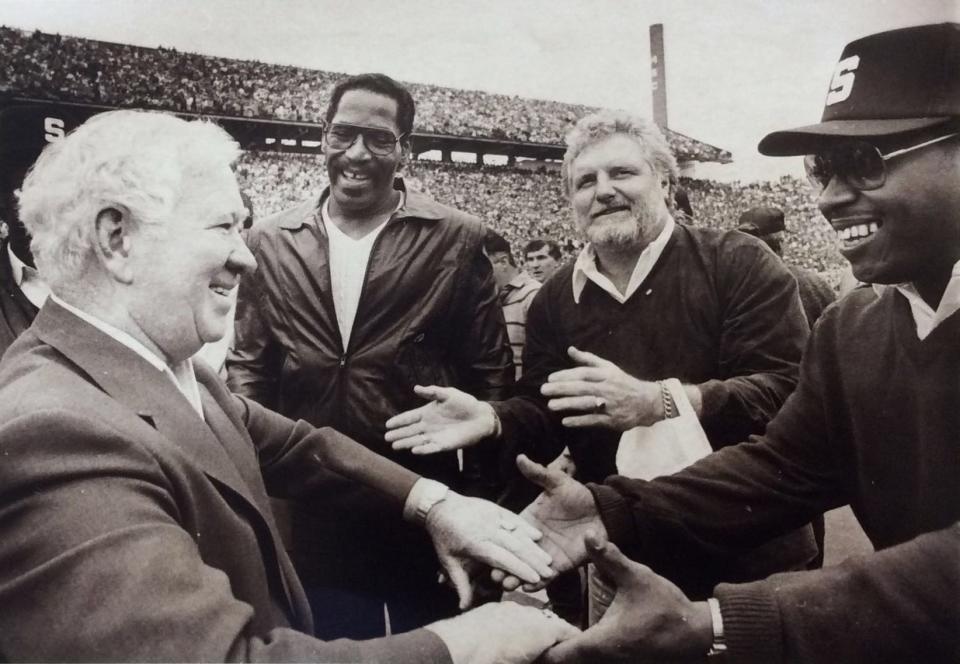 Duffy Daugherty, left, and three members of the 1965 powerhouse Spartan team meet during halftime of the MSU vs. Illinois game. Left to right, are, defensive ends Bubba Smith and Bob Viney, and linebacker Charlie "Mad Dog" Thornhill. They were on hand to celebrate the squad's 20th reunion, Oct. 19, 1985.