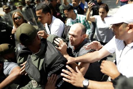 A man struggles with the national guard during a flash visit by Venezuela's chief prosecutor Luisa Ortega in front of the Public Prosecutor's office n Caracas, Venezuela August 5, 2017. REUTERS/Ueslei Marcelino