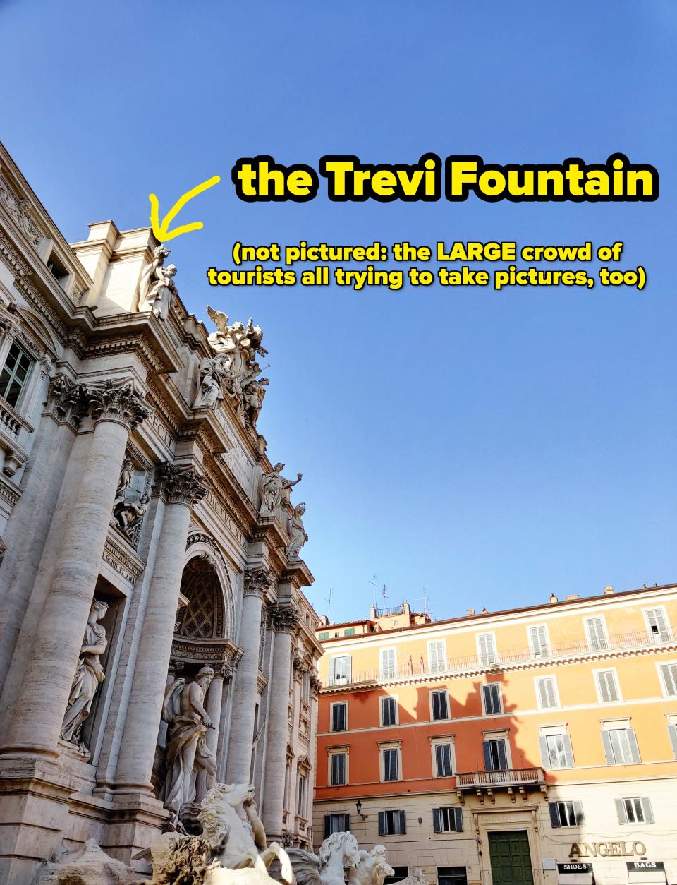 Trevi Fountain with sculptures in foreground and buildings under clear sky in Rome; a popular travel destination