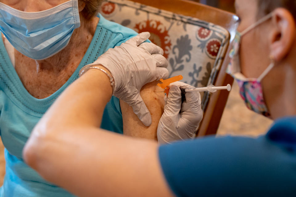 A health care worker administers a third dose of the Pfizer-BioNTech Covid-19 vaccine at a senior living facility in Worcester, Pa., in August.