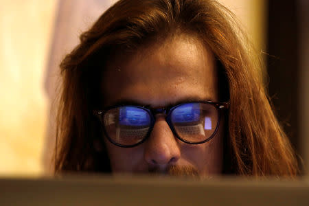 M Hanzala Tayyab, 24, a social media campaigner and cyber analyst, is seen working on computer at a local cafe in Islamabad, Pakistan March 13, 2019. REUTERS/Akhtar Soomro