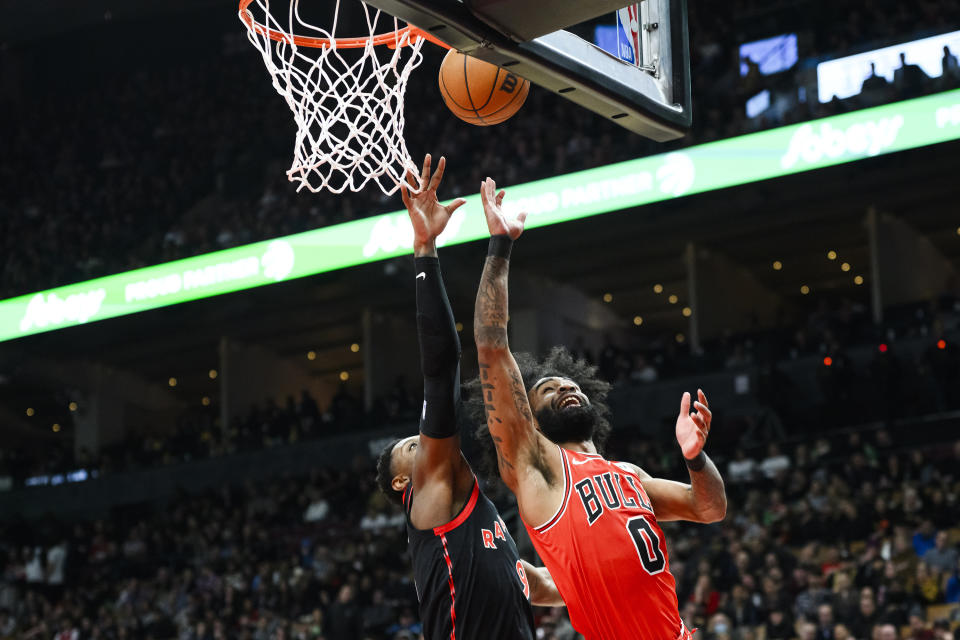 Chicago Bulls guard Coby White (0) scores while defended by Toronto Raptors guard RJ Barrett, left, during first-half NBA basketball game action in Toronto, Thursday, Jan. 18, 2024. (Christopher Katsarov/The Canadian Press via AP)