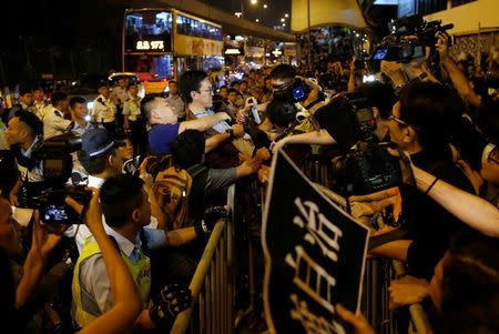 A demonstrator is detained by police during a protest against what they call Beijing's interference over local politics and the rule of law, a day before China's parliament is expected to announce their interpretation of the Basic Law in light of two pro-independence lawmakers' oath-taking controversy in Hong Kong, China November 6, 2016. REUTERS/Tyrone Siu