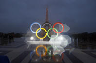 FILE - In this photo taken with a lens with rain drops shows the Olympic rings on Trocadero plaza that overlooks the Eiffel Tower, after the vote in Lima, Peru, awarding the 2024 Games to the French capital, in Paris, France, on Sept. 13, 2017. The Paris Olympics involve about 10,500 athletes from 200 countries or regions. But the Olympics are more than just fun and games. They are a giant business that generates billions of dollars in income for the International Olympic Committee. (AP Photo/Francois Mori, File)