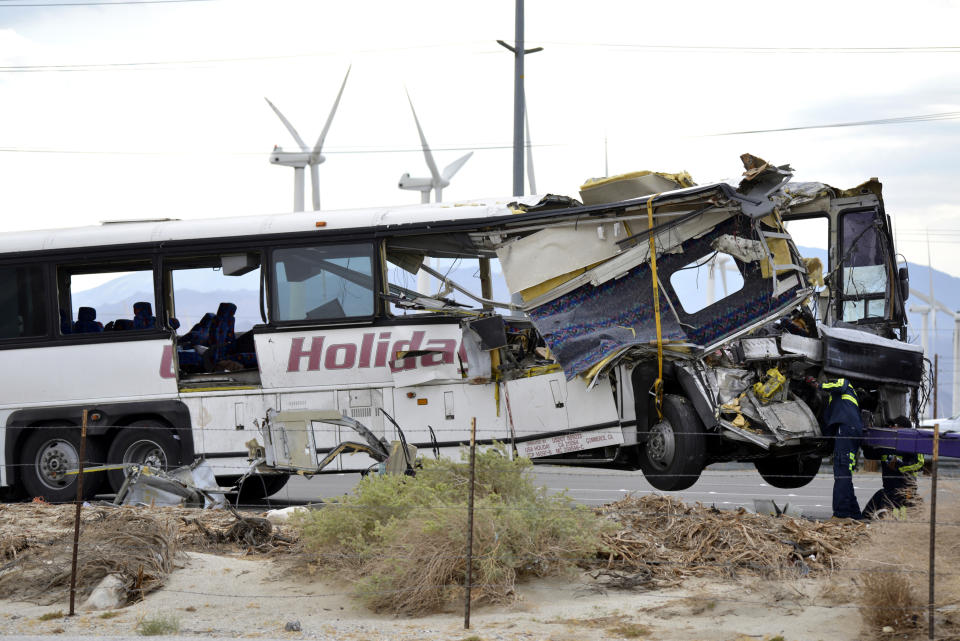 FILE - In this Oct. 23, 2016, file photo, workers prepare to haul away a tour bus that crashed with semi-truck on Interstate 10 just west of the Indian Canyon Drive off-ramp, in Desert Hot Springs, near Palm Springs, Calif. Officials say Bruce Guilford, a trucker who fell asleep behind the wheel was sentenced, Friday, Aug. 30, 2019, to four years in state prison after he pleaded guilty to causing a tour bus crash on a Southern California freeway that killed 13 people in 2016. (AP Photo/Rodrigo Pena, File)
