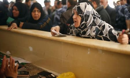 A Palestinian woman asks for a travel permit to cross into Egypt, at the Rafah crossing between Egypt and the southern Gaza Strip March 9, 2015. REUTERS/Suhaib Salem