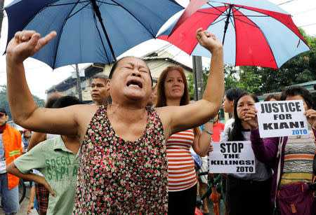 A woman, whose son was also shot in a drug-related killing, cries during the funeral march of Kian delos Santos, a 17-year-old student who was shot during anti-drug operations in Caloocan, Metro Manila, Philippines August 26, 2017. REUTERS/Erik De Castro